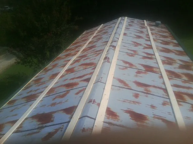 Rusted metal roof panels with new wood purlins before replacement — Storm Damage Roof Repair in Keithville by Roofing Brothers
