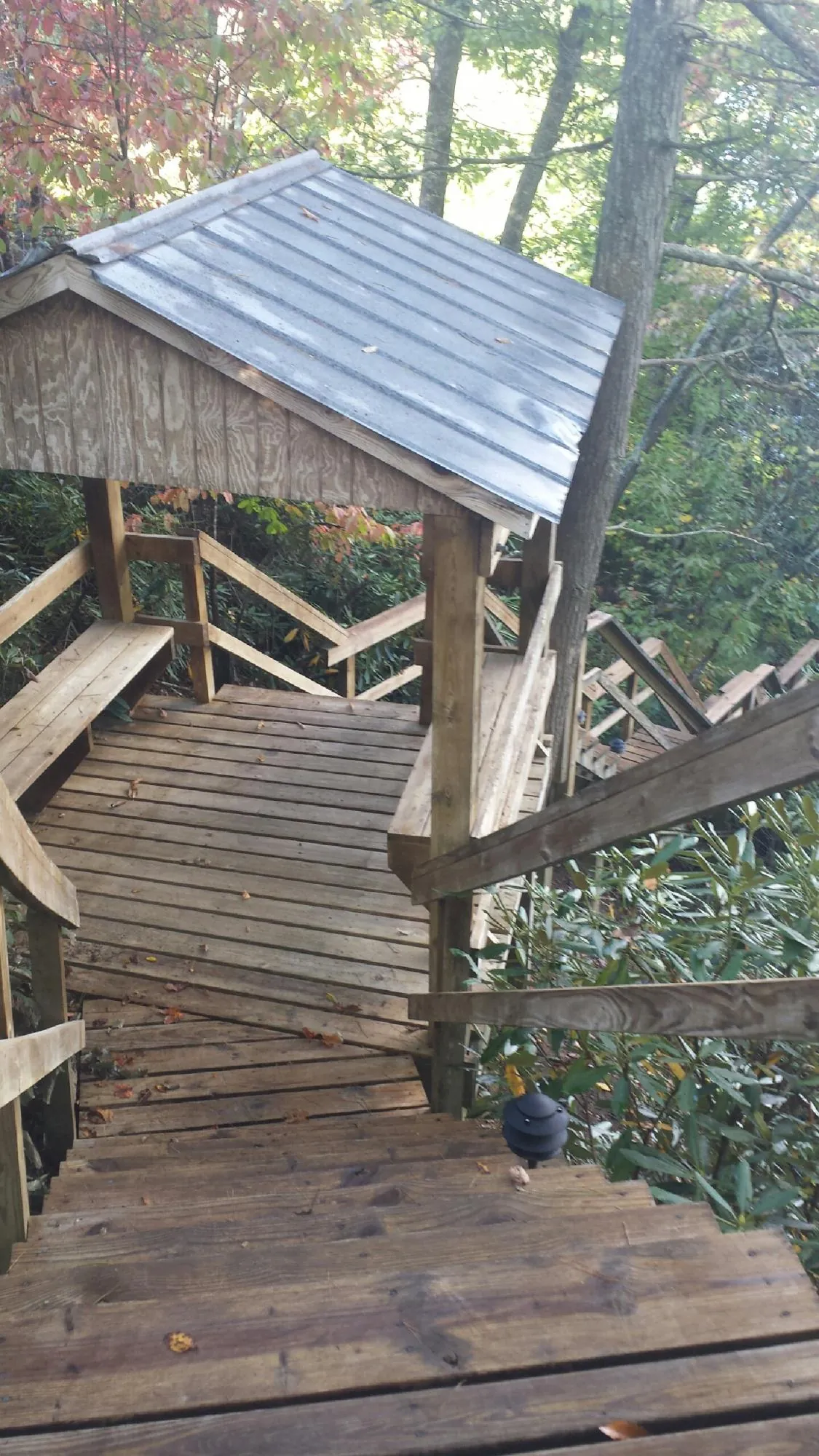 Metal roofed shelter over wooden steps on a wooded walkway — Skylight Repair & Installation work by our crew in Keithville