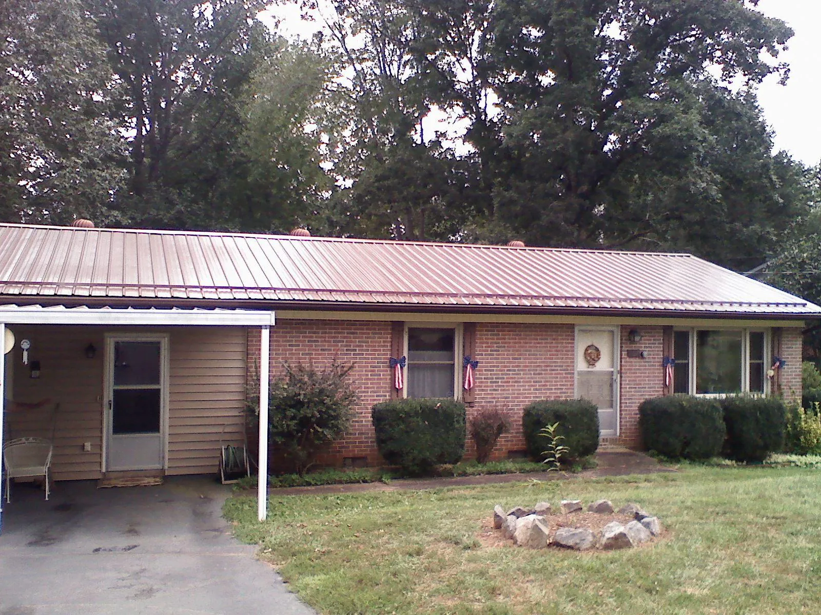 Bronze metal roof and carport on a brick ranch home — Roof Repair work by our crew in Keithville